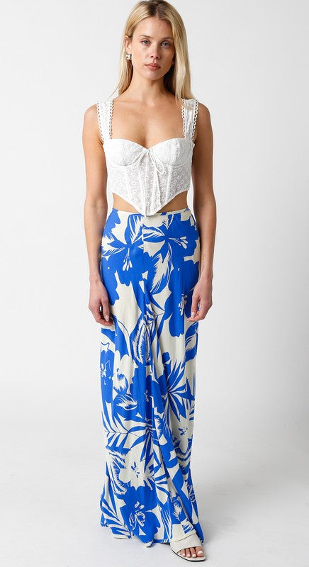 model is wearing White Cheyanne Top and blue palm print maxi skirt and white sandals 