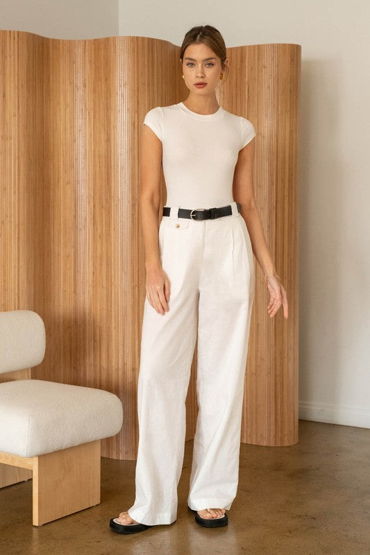 model is wearing White Round Neck Bodysuit with matching white pants a black belt and sandals