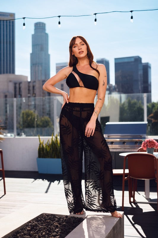 model is wearing Black See Through Cover Up Pants with black mesh bikini set