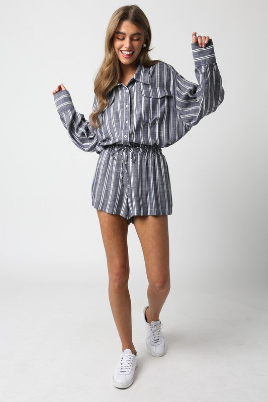 model is wearing Navy White Bonnie Linen Romper with white sneakers 