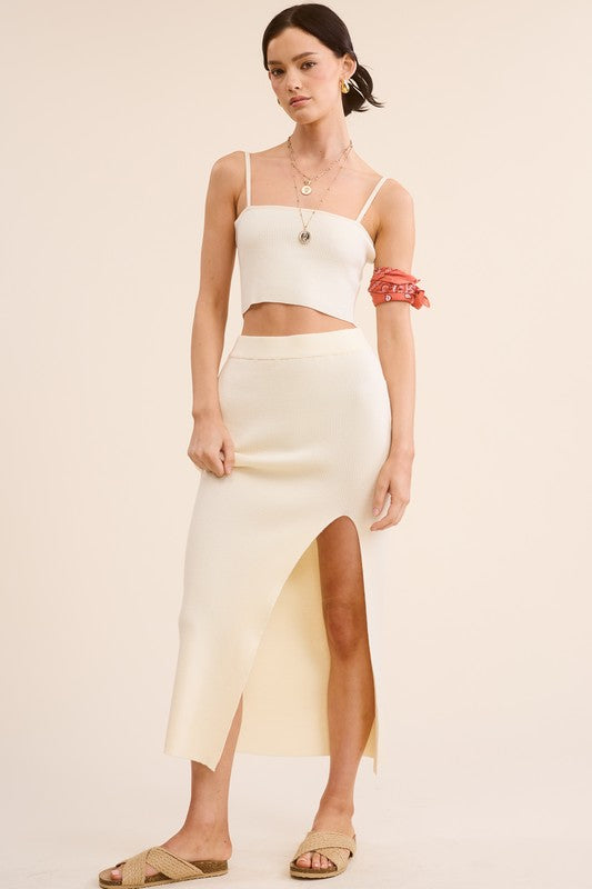 model is wearing Ivory Haddy Skirt Set with gold necklace set and beige slide sandals