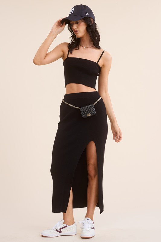 model is wearing Black Haddy Skirt Set with a black baseball cap, a chic fanny bag and white sneakers 