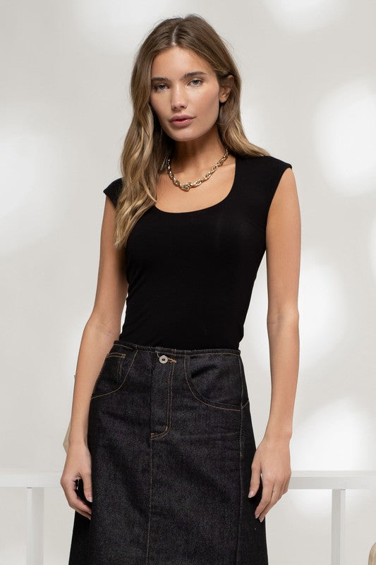 model is wearing Black Reversible Knit Sleeveless Crop Top with dark denim maxi skirt and gold chunky necklace 