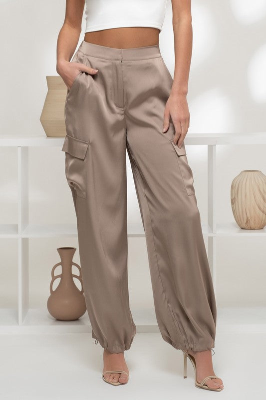 model wearing Taupe Satin Cargo Jogger Pants wiht gold heels 