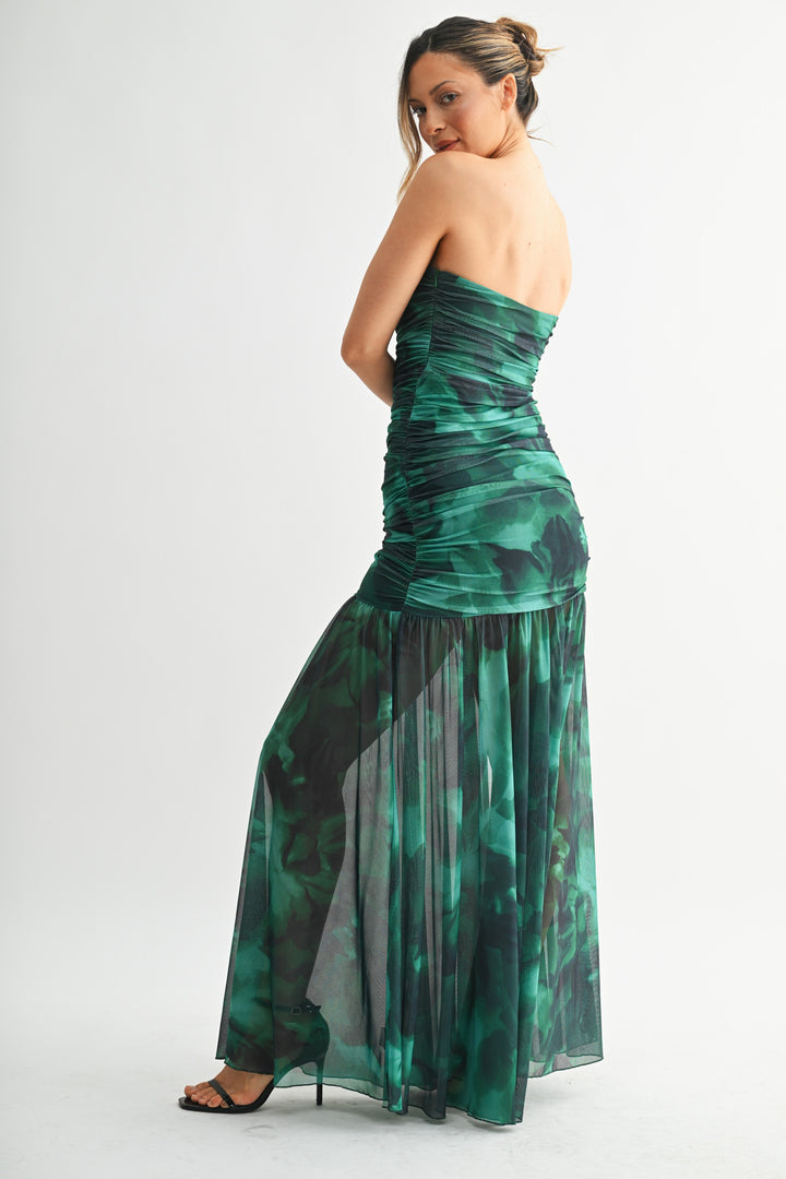 Woman wearing a strapless green dress with black accents on a white background