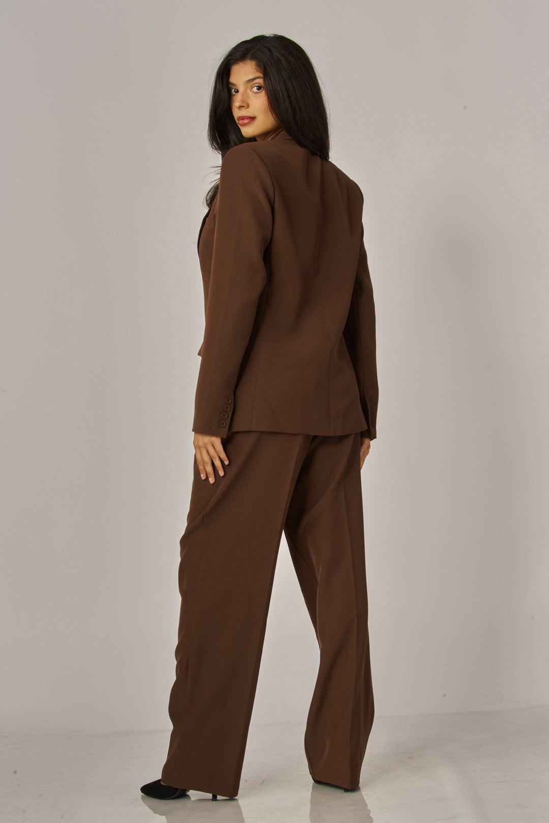 Back three-quarter view of the espresso brown boyfriend blazer with brown trousers