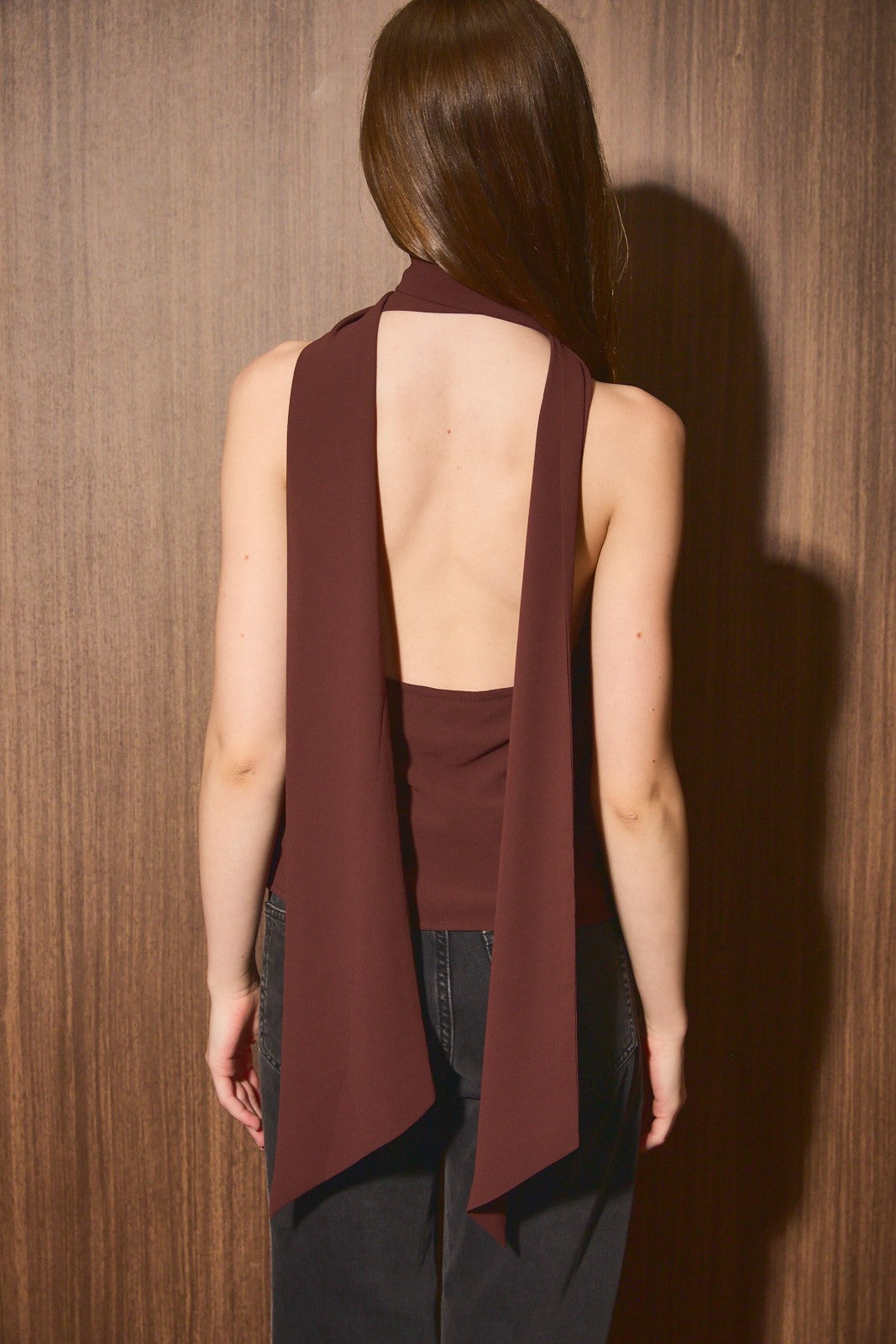 Back view of the dark brown cowl neck top showing the open back and trailing scarf ties