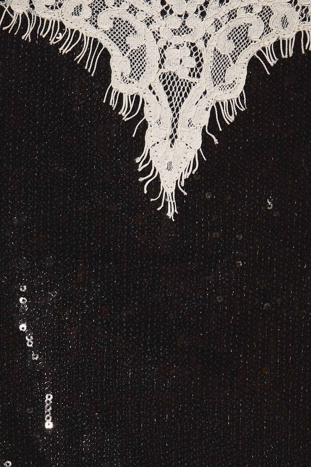 Close-up of the black sequins and cream eyelash lace trim on the sweetheart neckline