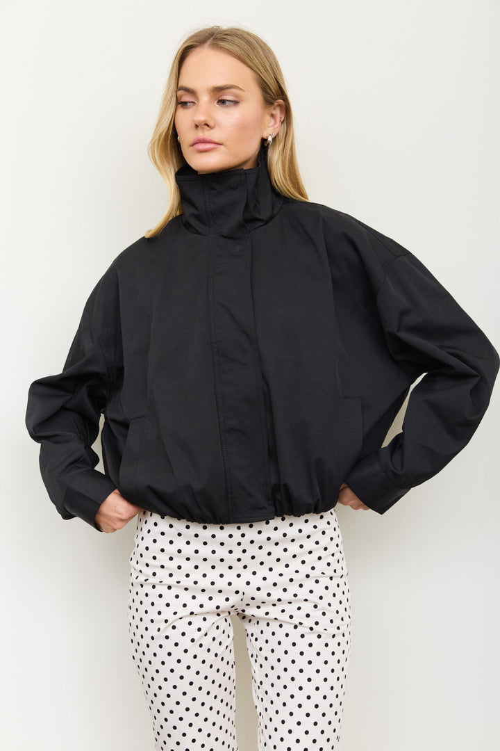 Three-quarter view of the black mock neck bomber-style zip jacket, a fall going-out layer