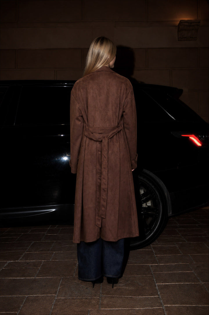 Back view of the dark brown suede trench coat with tie belt at night, a fall outerwear look