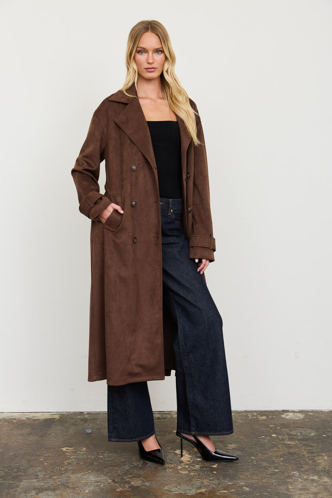 Three-quarter view of the brown suede trench coat with lapel collar, a Thanksgiving travel outfit