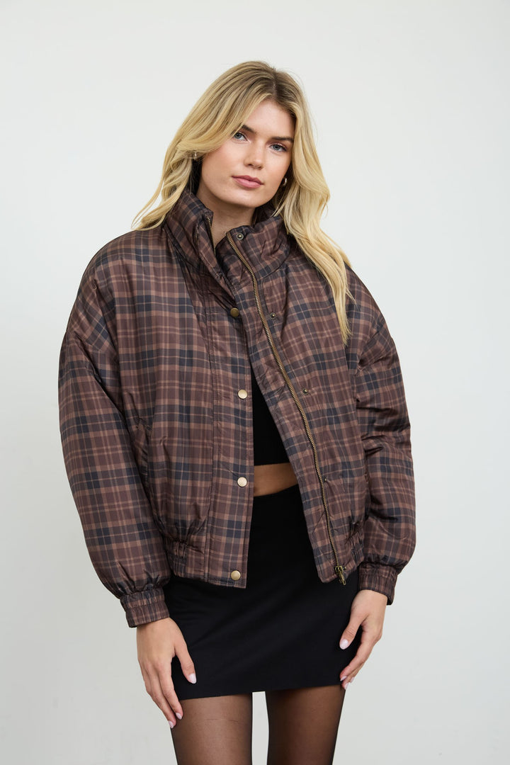 Front view of the brown plaid cropped puffer jacket zipped up with funnel neck