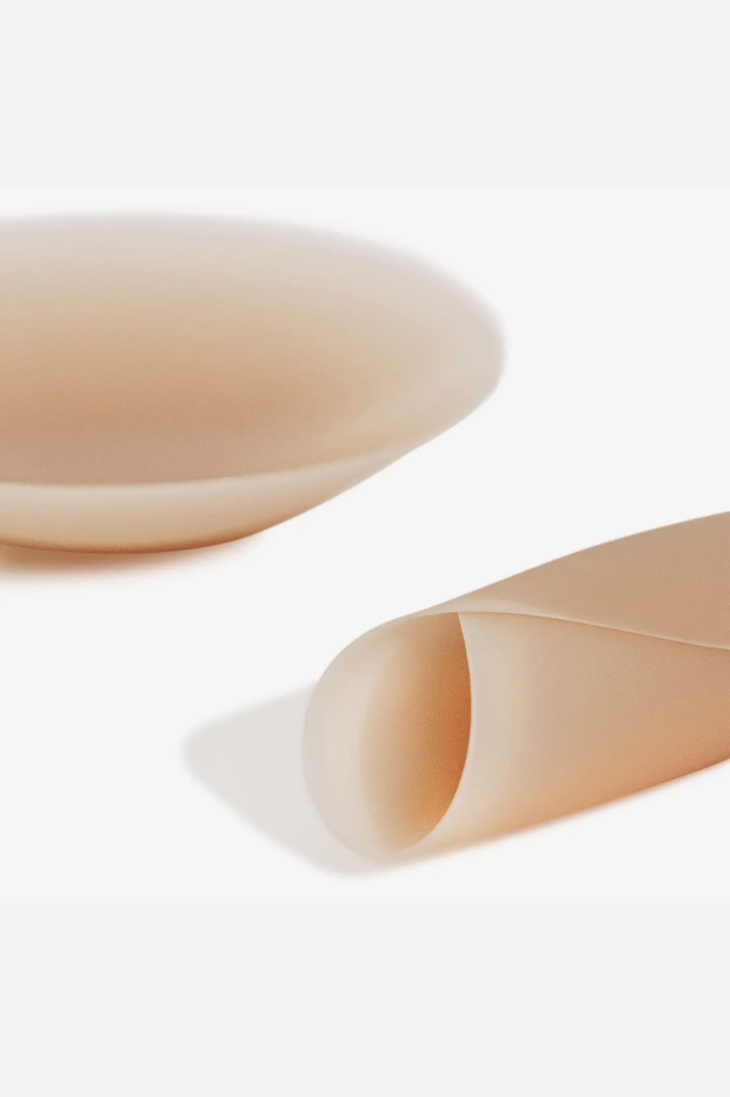 Two beige-colored pastries on a white surface