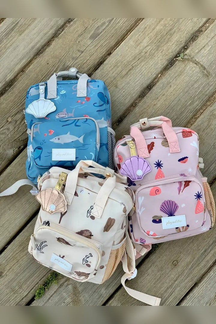 Mini school backpack with shark design and a name label on the shell