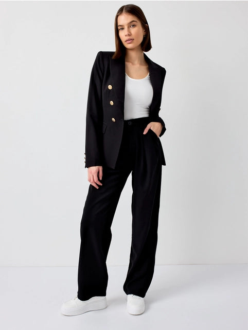 model is wearing Black Fitted Blazer Jacket  with a white basic top and matching black pants with white sneakers