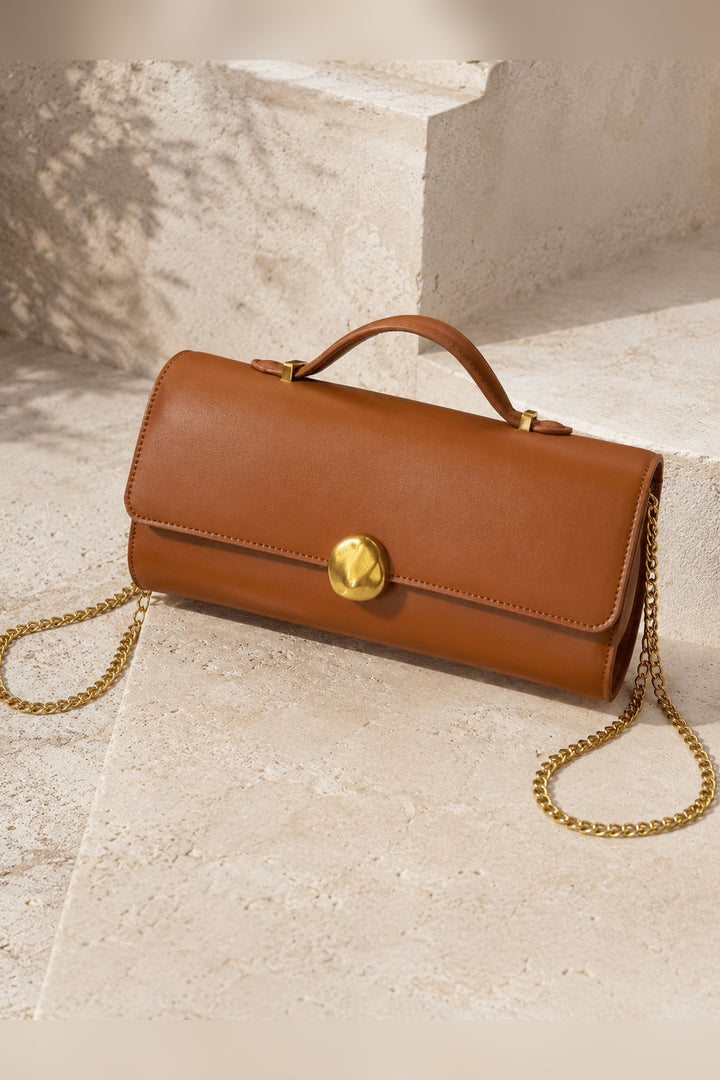 Tan top handle clutch bag with a sleek silhouette