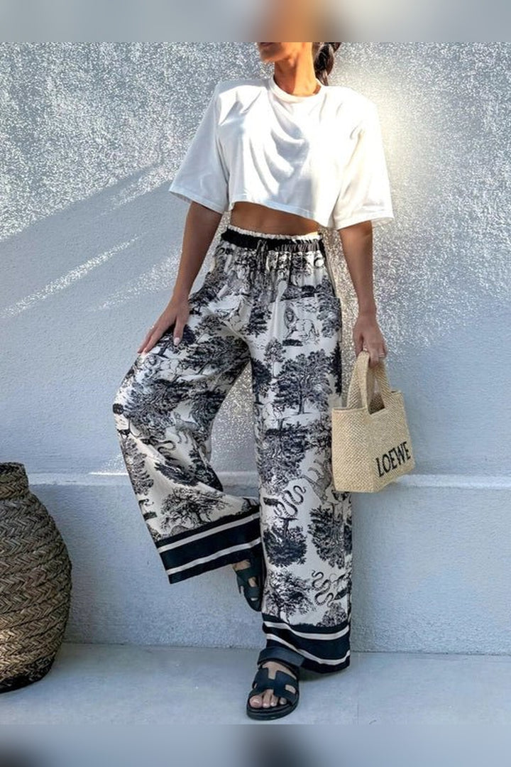 Black scenic print pants in a lightweight woven fabric with a relaxed leg