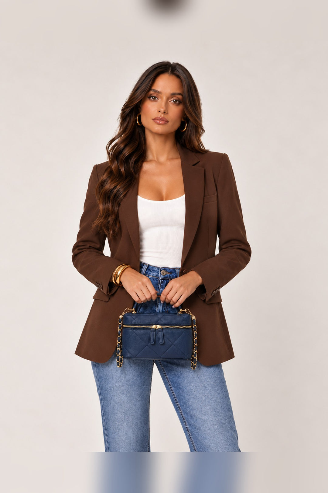 Navy quilted crossbody carried by its curved top handle