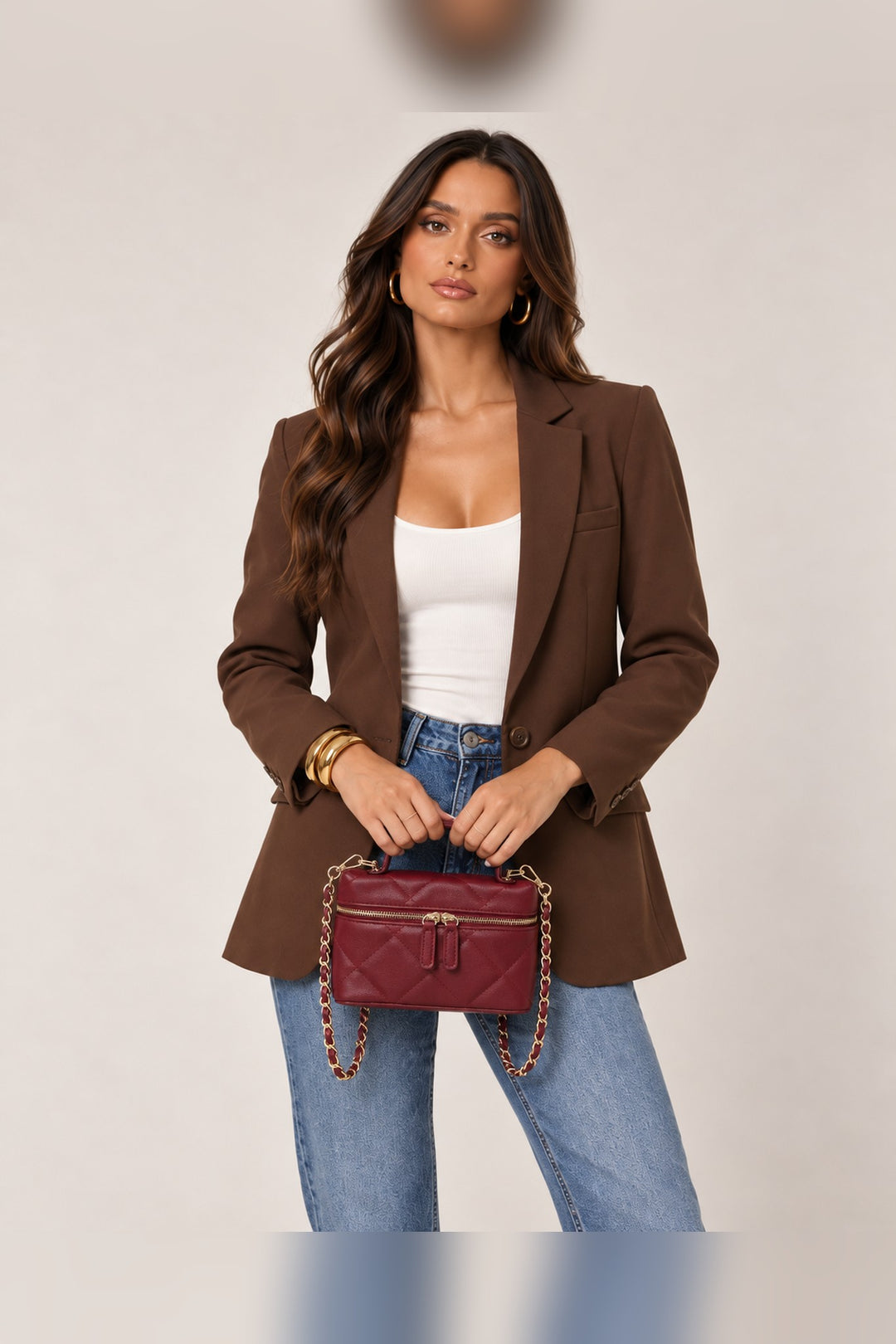 Burgundy quilted crossbody carried by its curved top handle