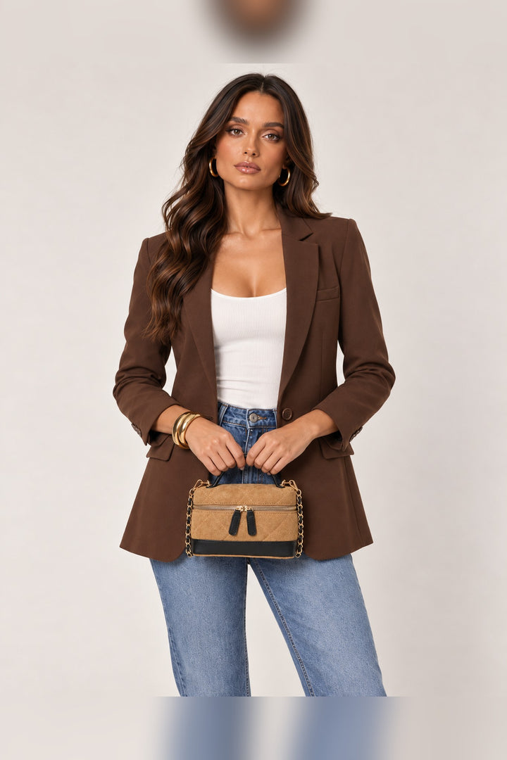 Tan quilted crossbody carried by its black top handle
