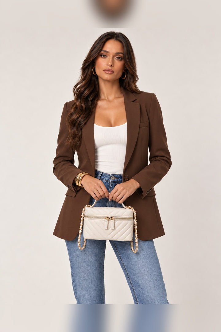 Ivory chevron-quilted crossbody carried by its top handle