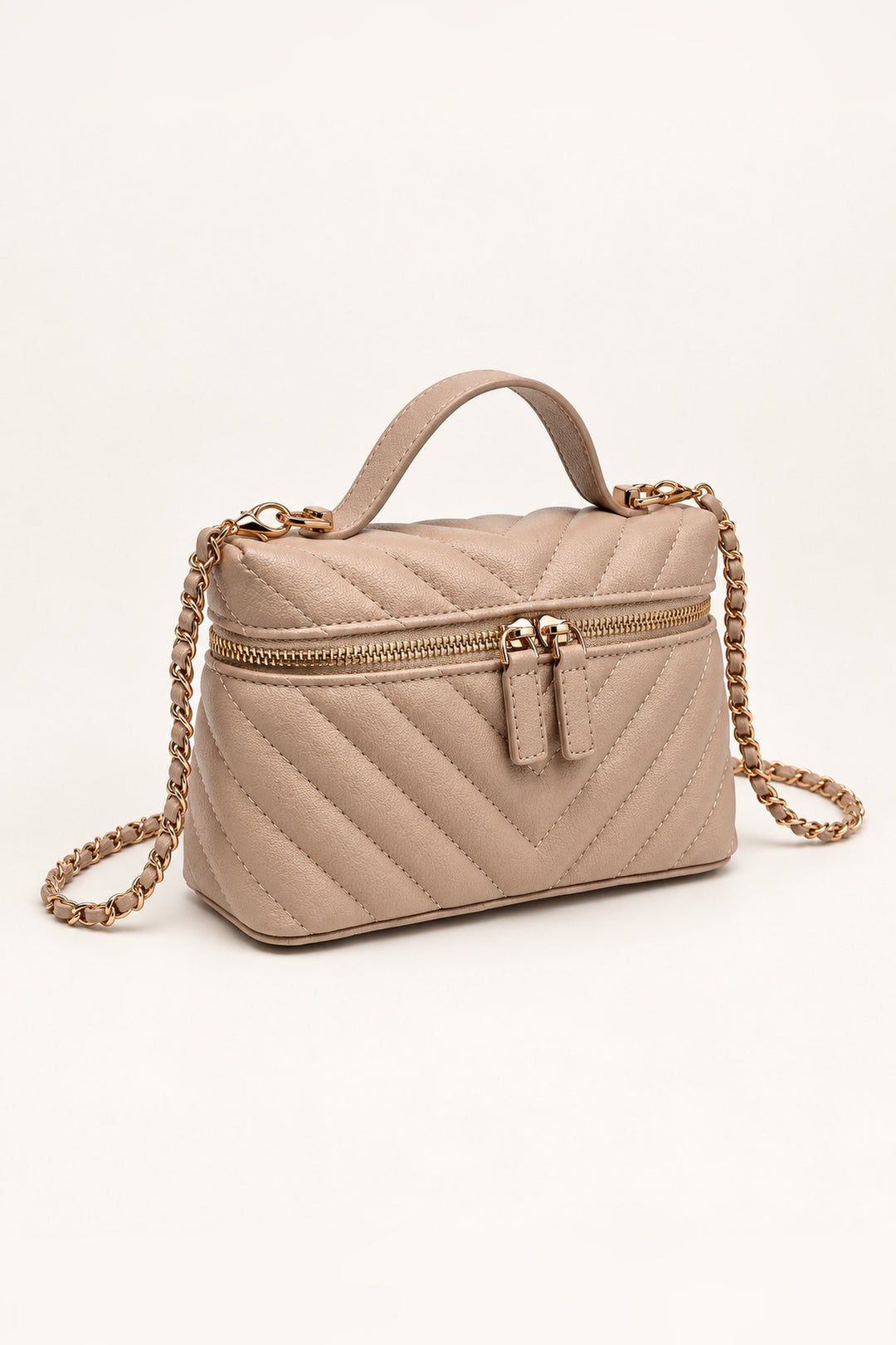 Beige chevron-quilted crossbody at an angle showing its compact structured shape