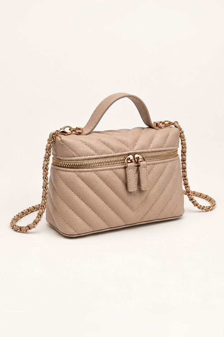 Beige chevron-quilted crossbody at an angle showing its compact structured shape
