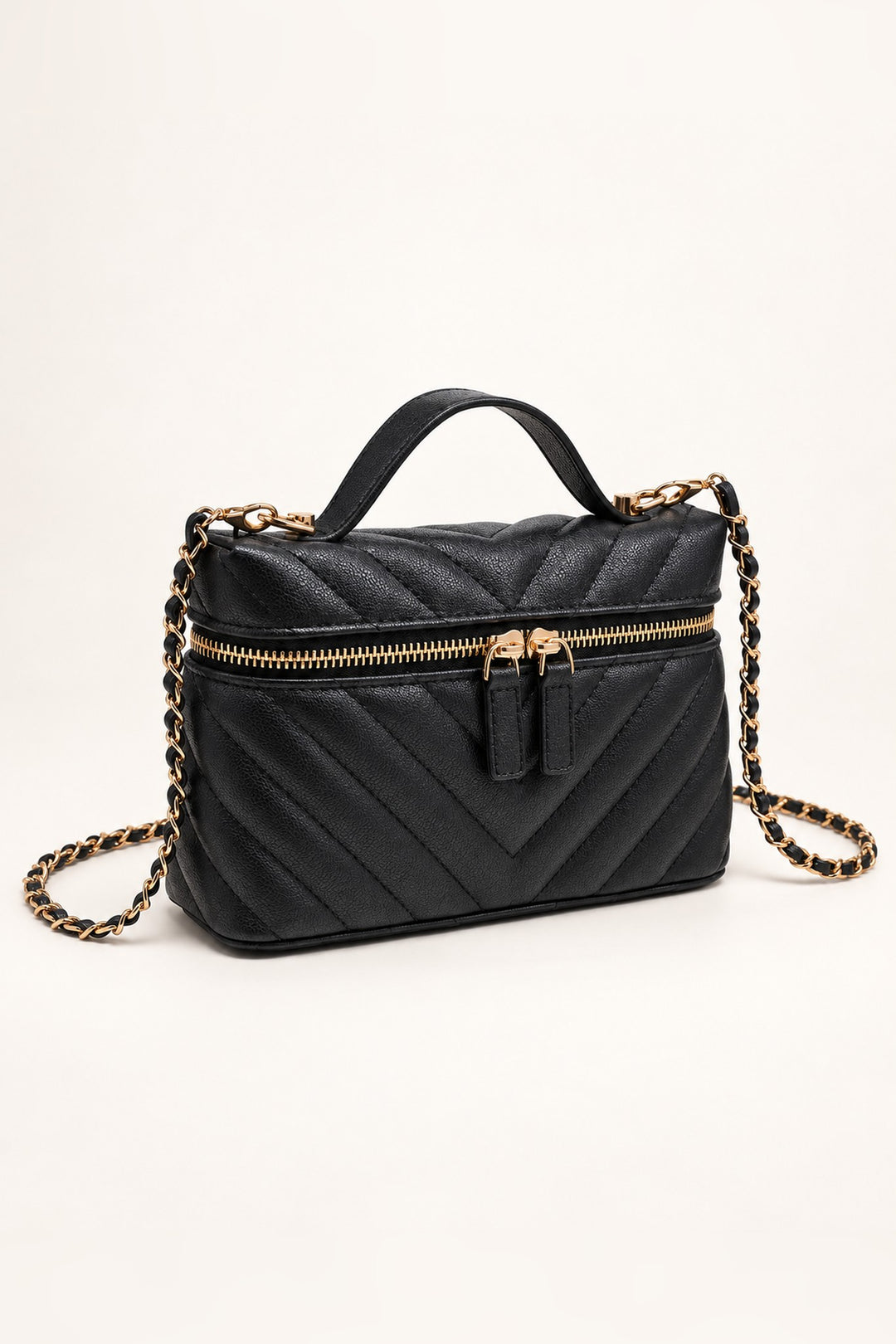 Black chevron-quilted crossbody at an angle showing its compact structured shape