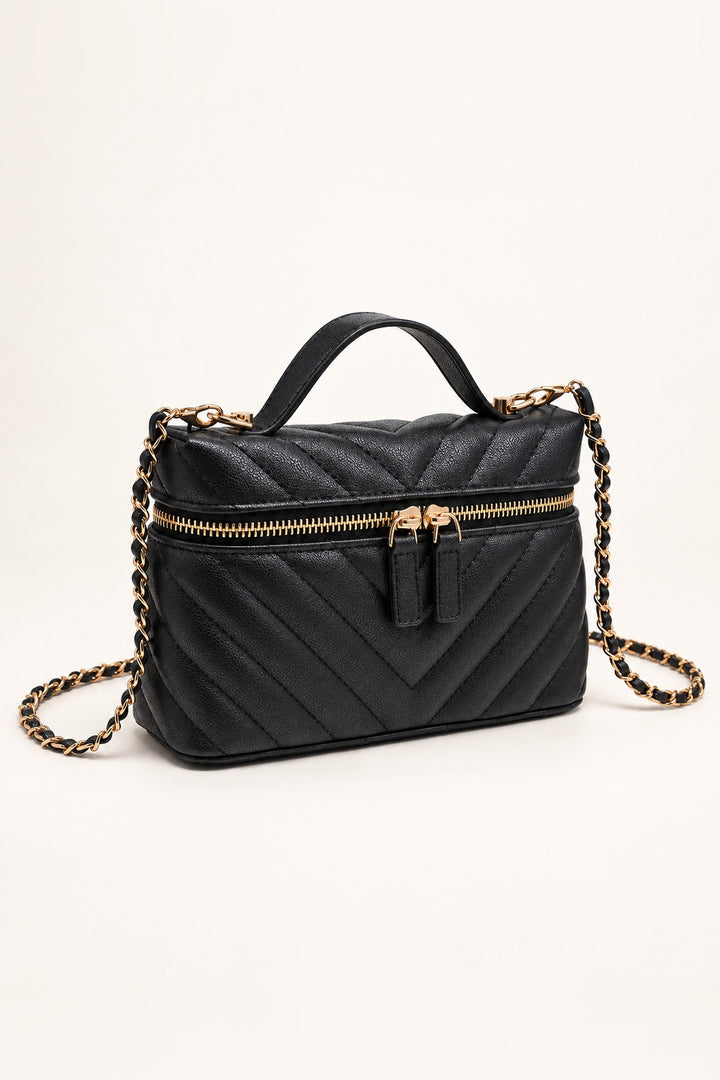 Black chevron-quilted crossbody at an angle showing its compact structured shape