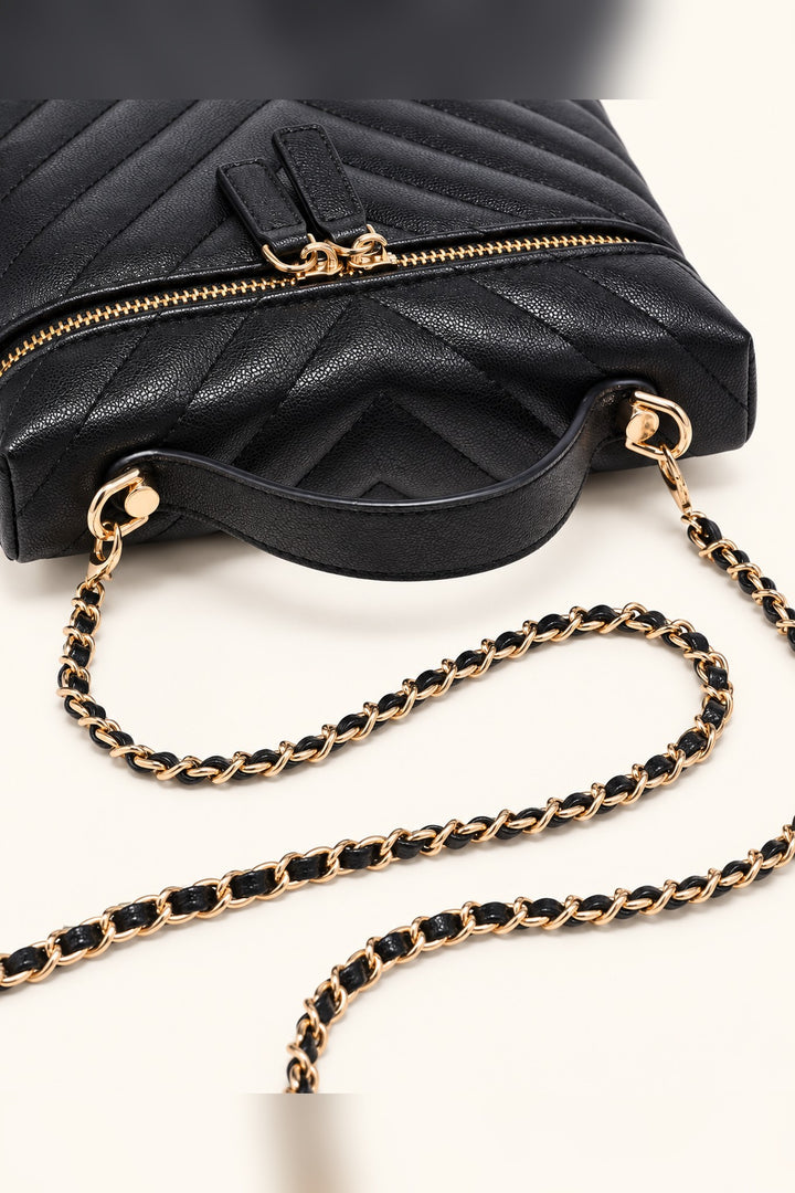 Close detail of the chevron quilting and gold dual zip pulls on the black Sella crossbody