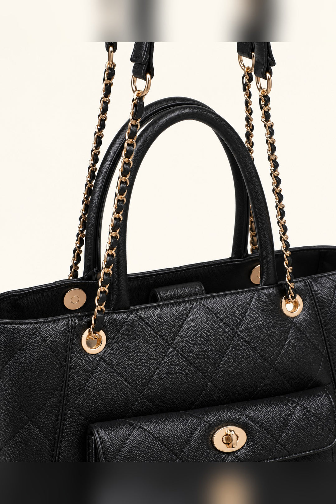 Close detail of the diamond quilting and gold turn-lock clasp on the black Hank tote