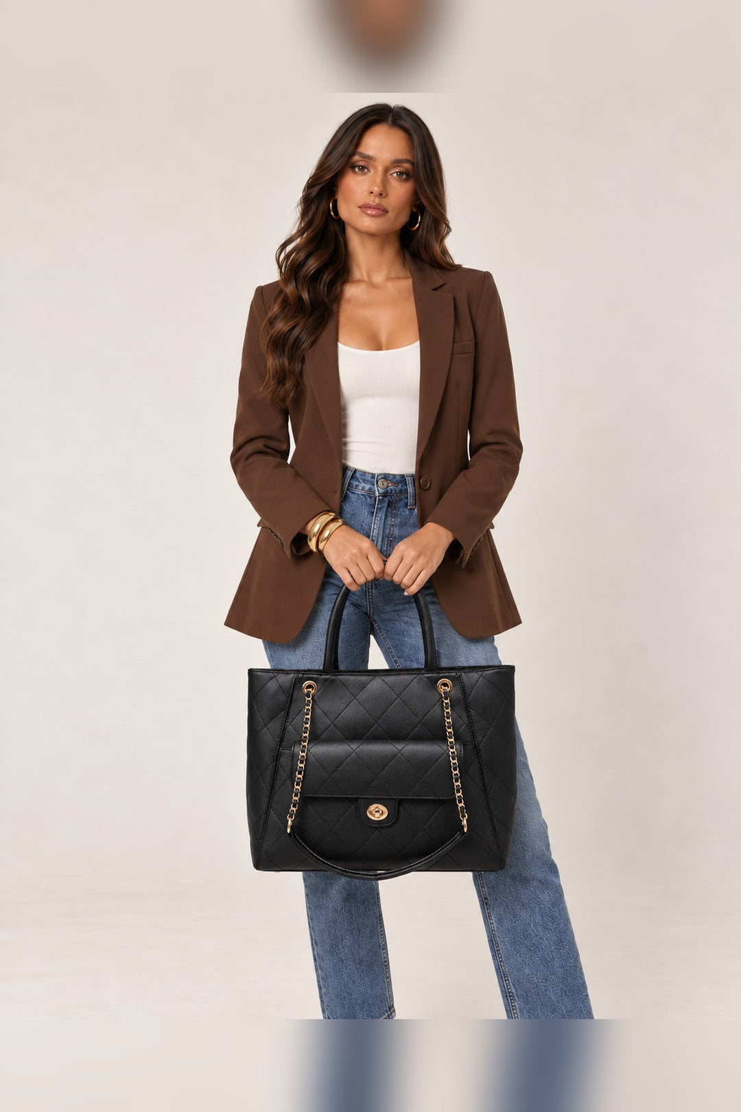 Black quilted tote carried by its rolled top handles