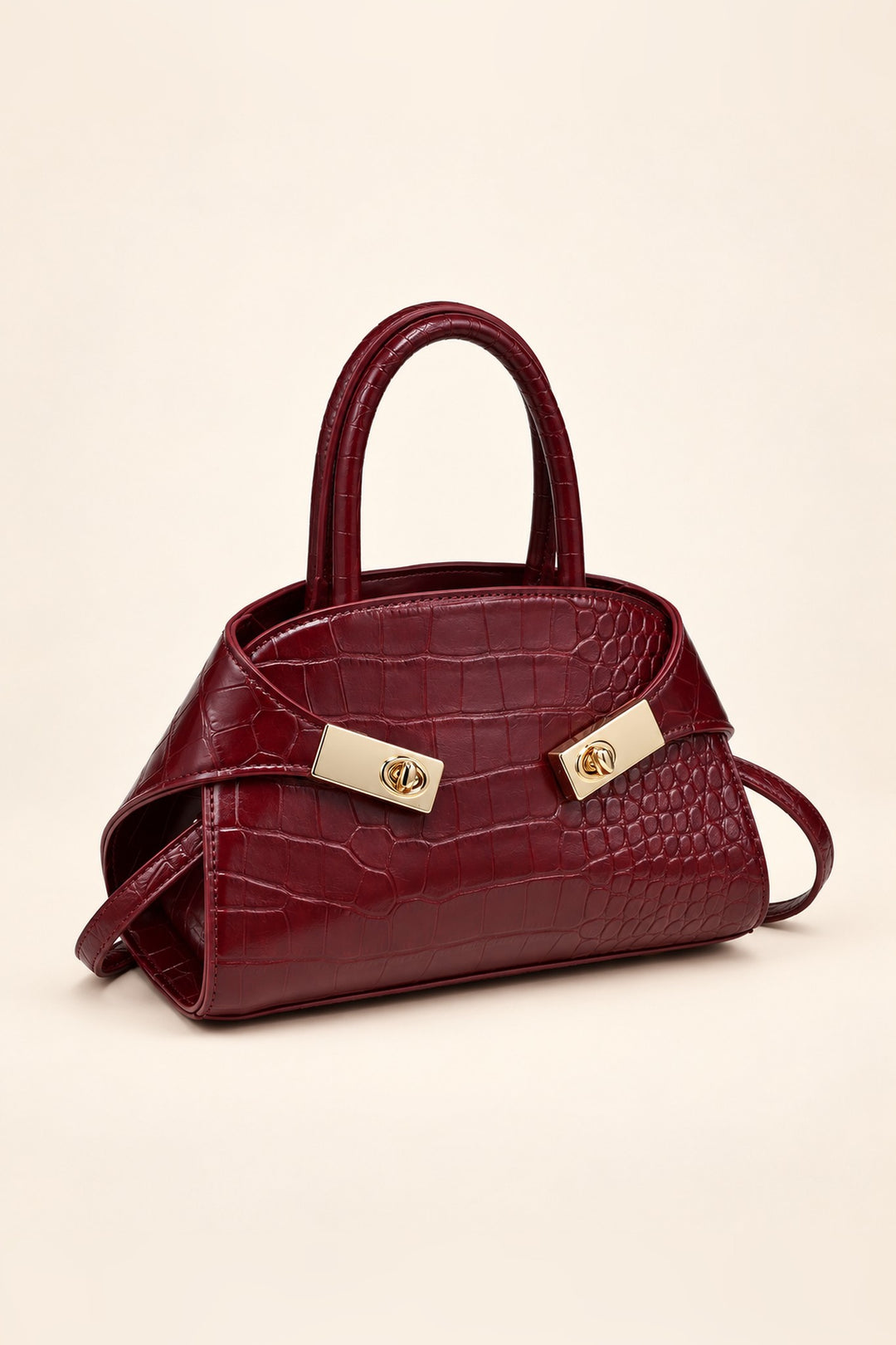 Burgundy croc-embossed crossbody at an angle showing its compact structured shape