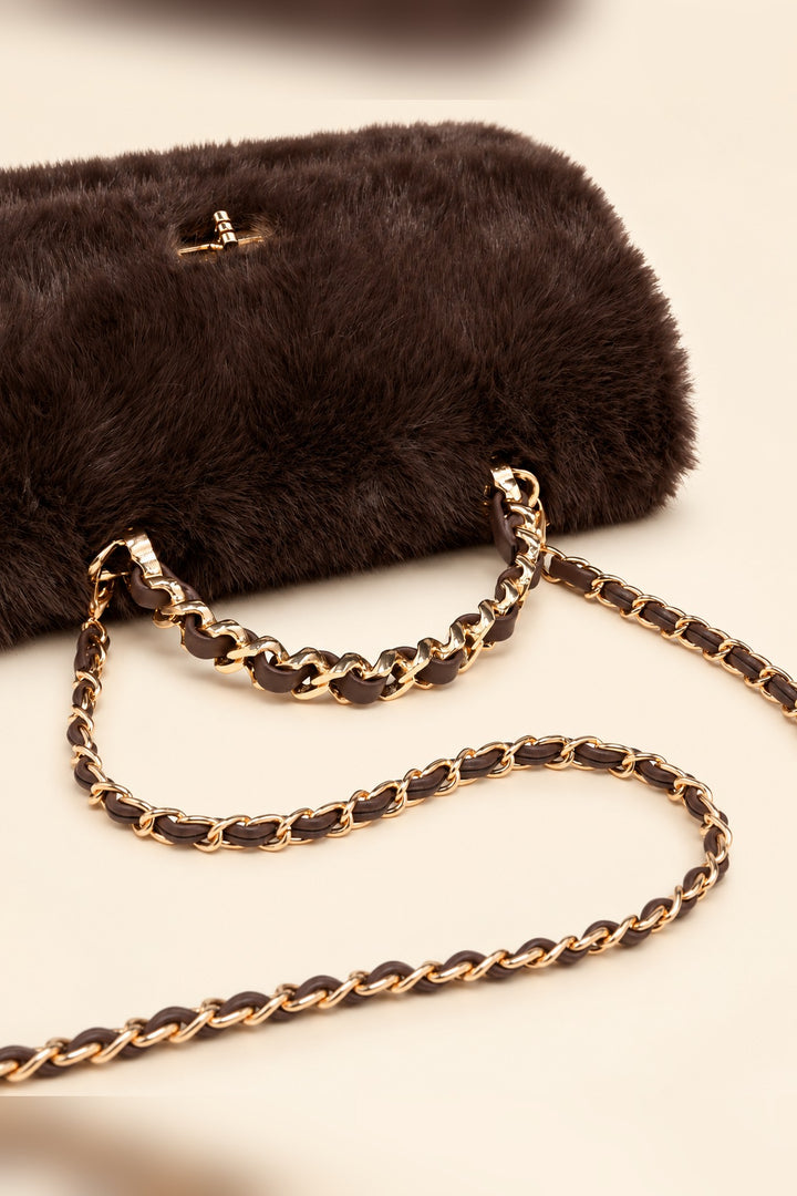 Close detail of the gold turn-lock and chain handle on the chocolate brown Lulu crossbody