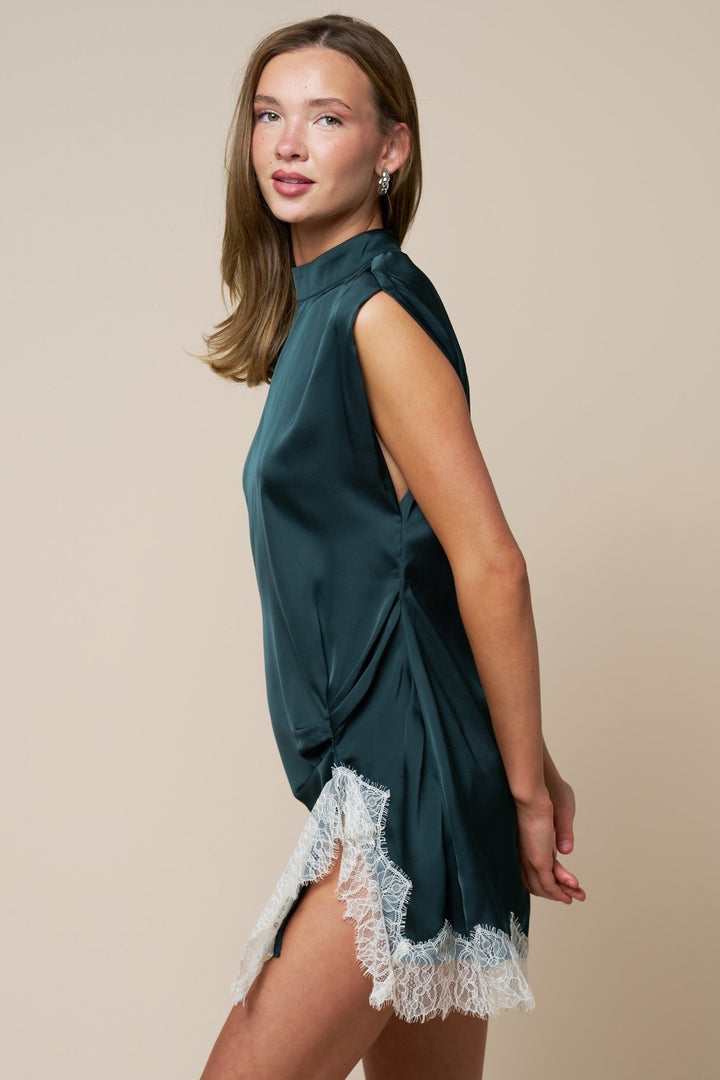 Side view of the hunter green satin mini dress showing the ivory eyelash lace trim