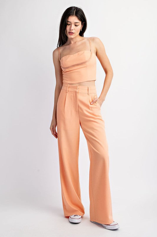 model is wearing Peach Double Waist Trousers  with matching top and white sneakers 