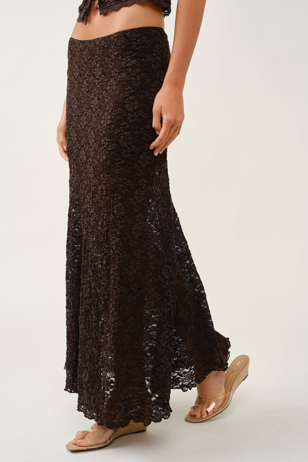 Rear detail of the brown floral lace maxi skirt showing the A-line flare and sheer scalloped hem