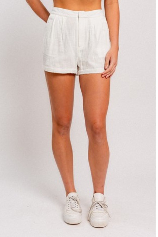 model is wearing White High Waisted Linen Shorts and white sneakers 