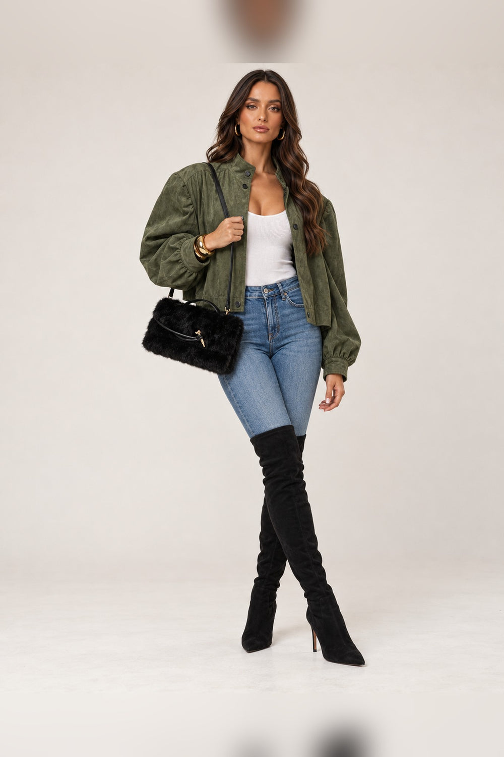 Model wearing the black faux fur Ada bag with an olive jacket, white tank and jeans, a fall outfit