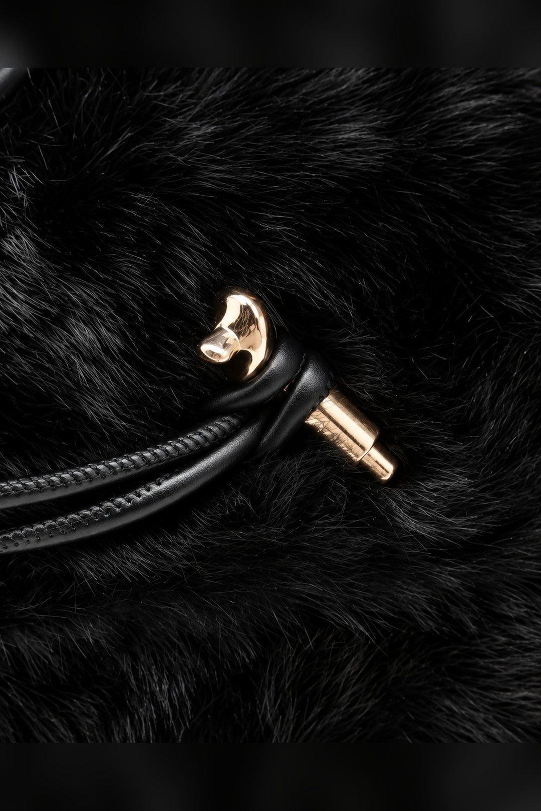 Close-up of black faux fur, cord trim and gold-tone hardware on the Ada bag