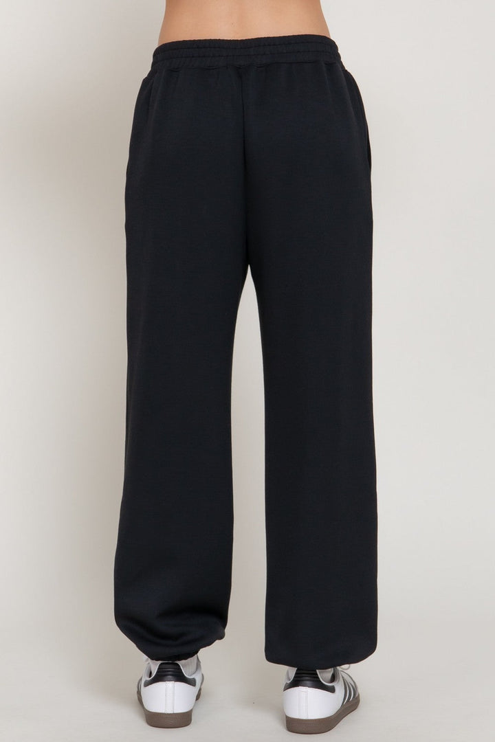 Black scuba flare pants with fitted waistband, front detail
