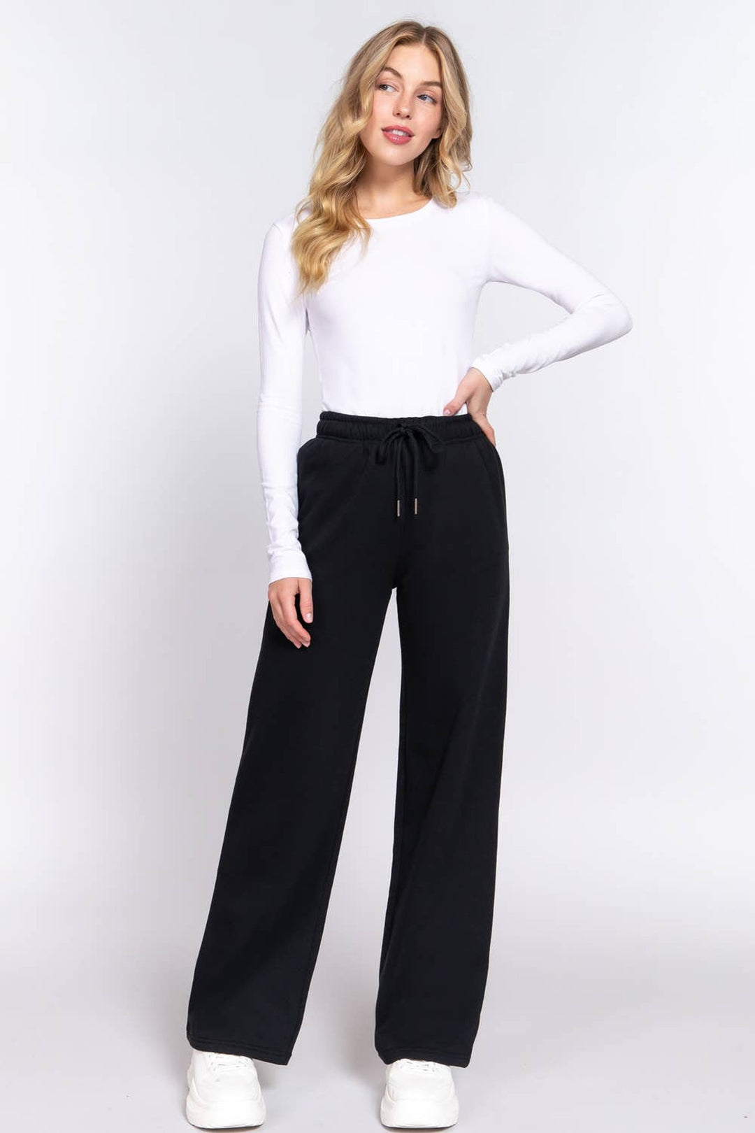 Full-length view of the Black Fleece Joggers with a white long sleeve top and sneakers, a fall lounge outfit
