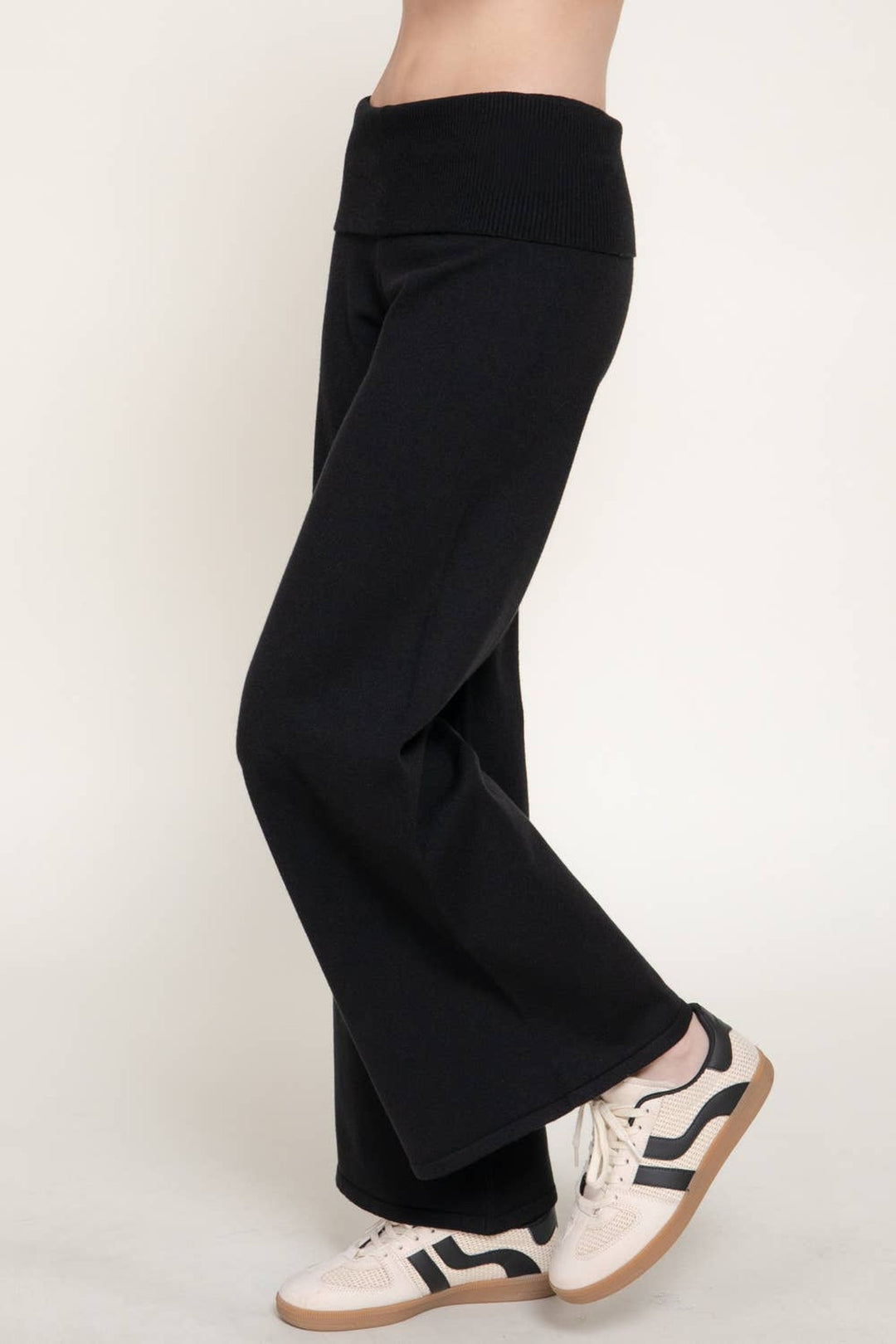 Side view of the black fold over waist sweater pants showing the wide leg drape