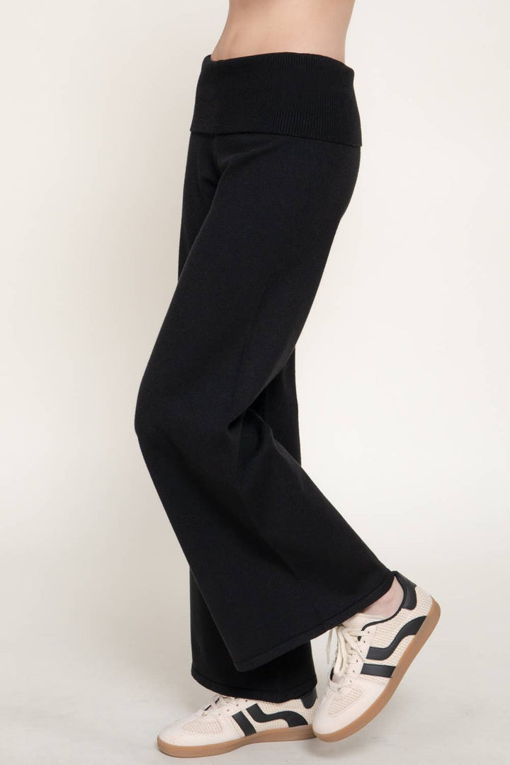 Side view of the black fold over waist sweater pants showing the wide leg drape