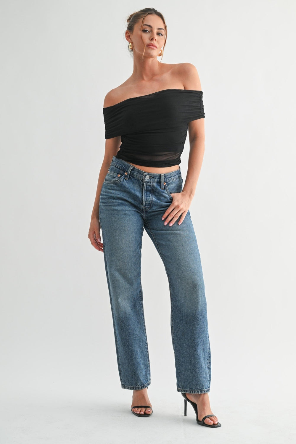 Fitted black mesh top with gathered ruching along the sleeves