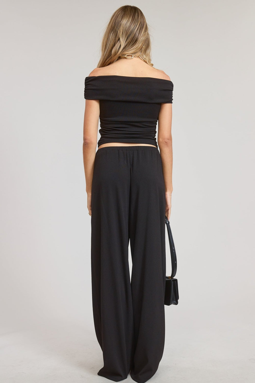 Wide leg black pants styled with the coordinating off-shoulder top