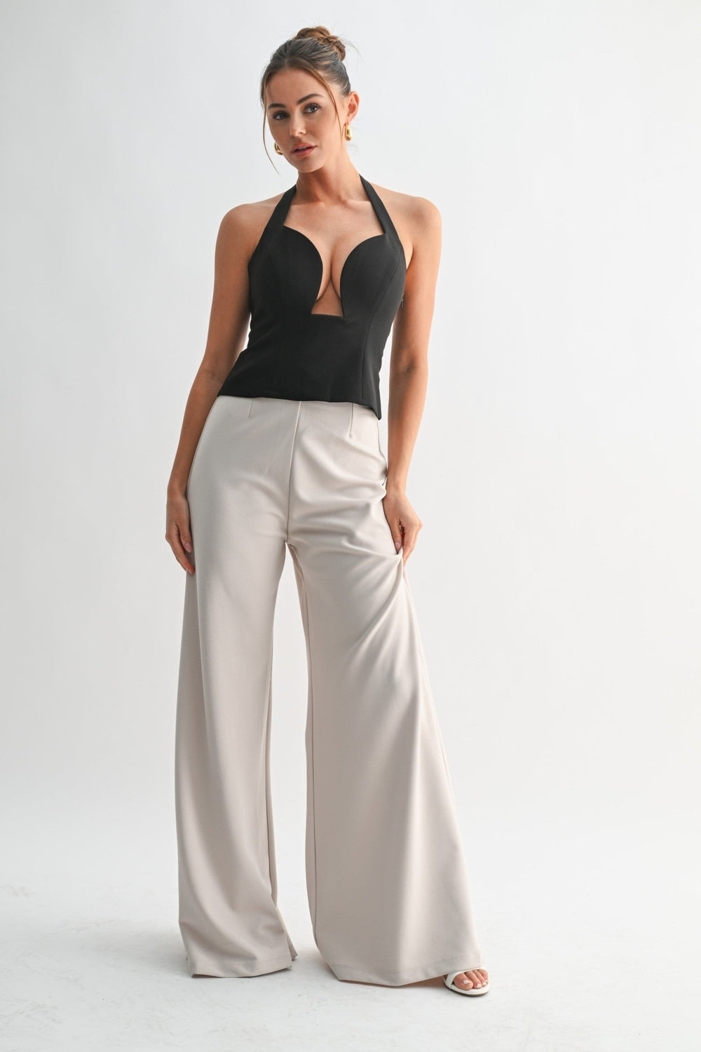 Button detailing at the halter neckline of the black peplum top
