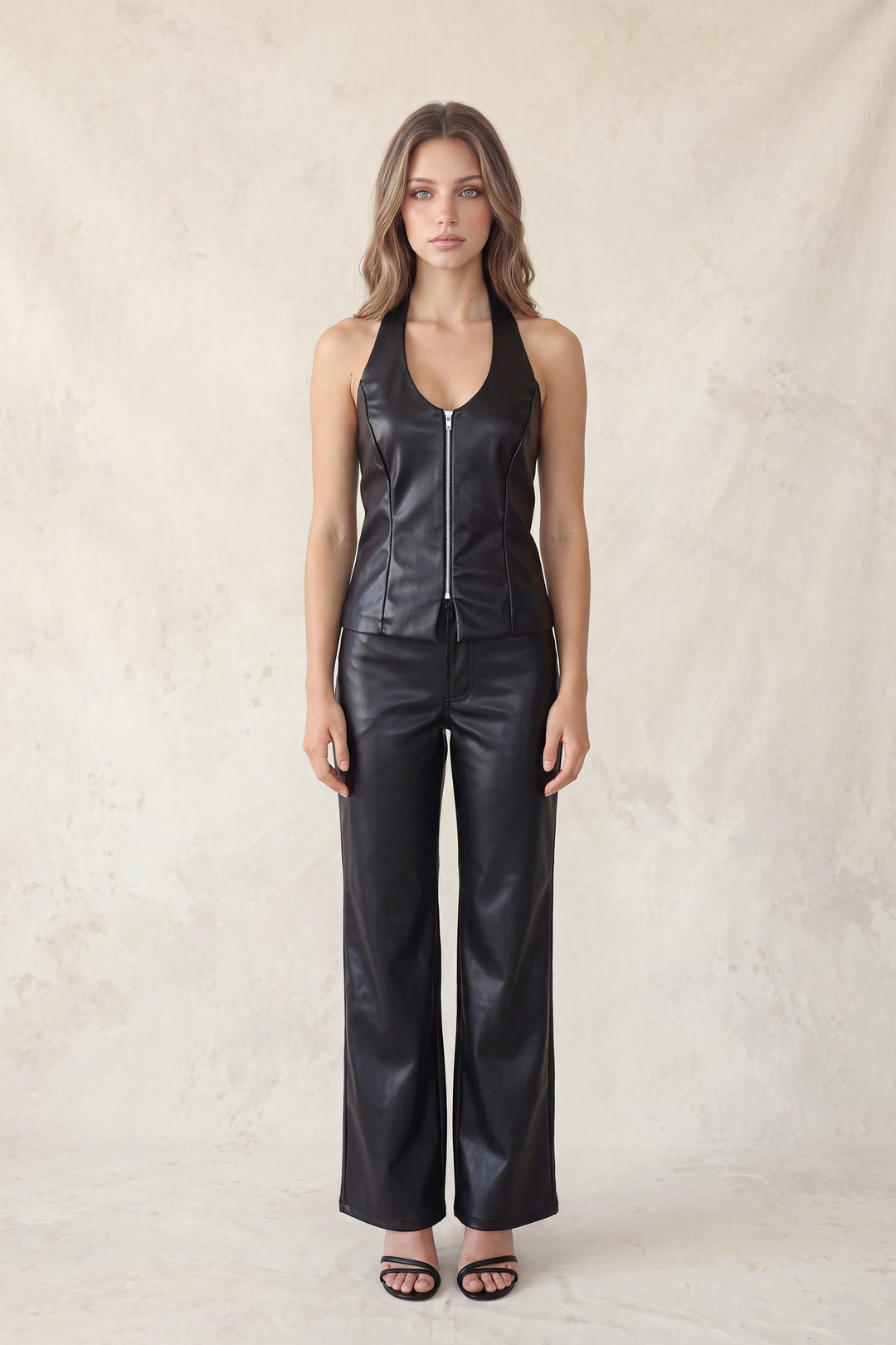 Black faux leather pants styled with a black halter top, full length