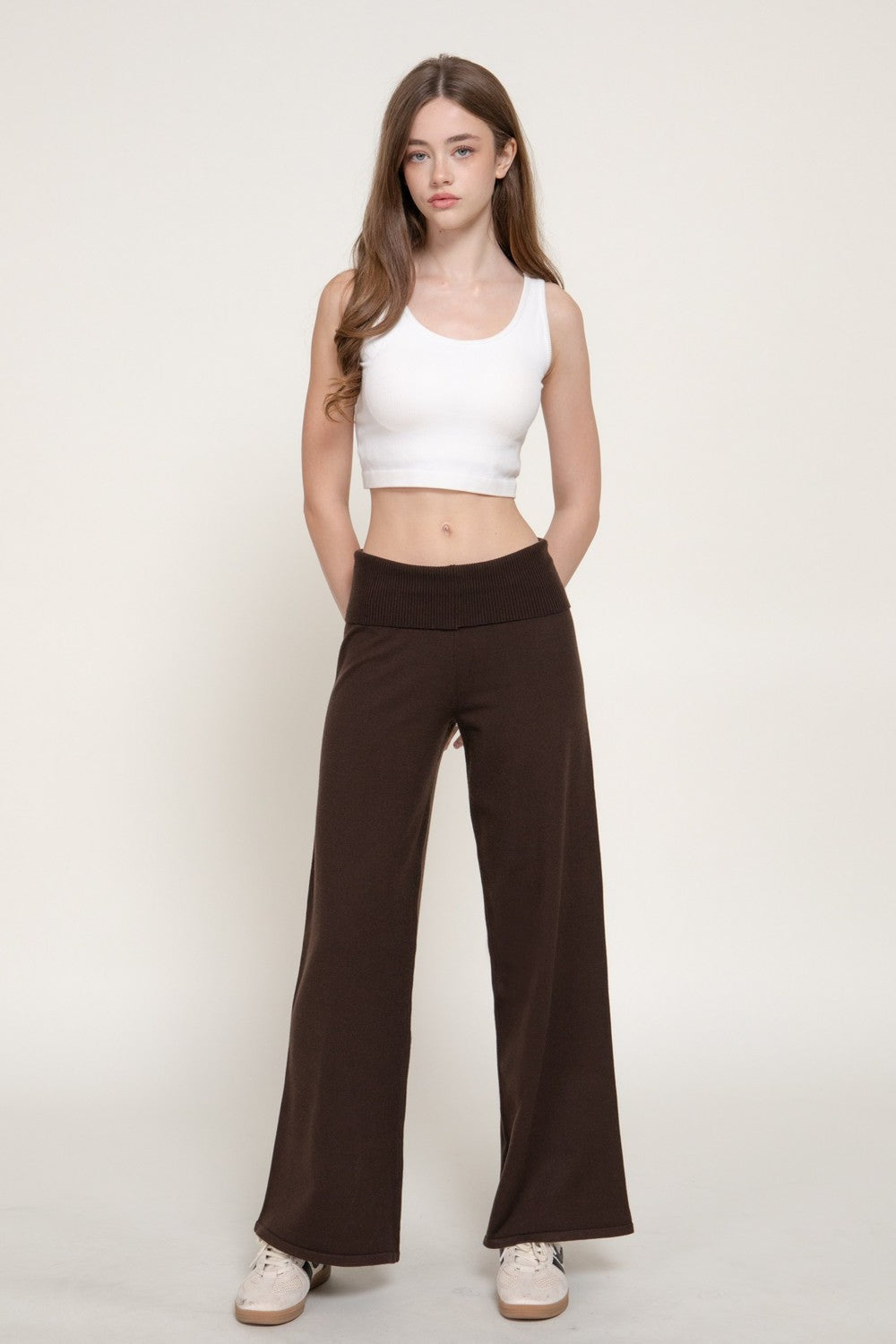 Front view of the brown fold over waistband wide leg sweater pants with a white tank top