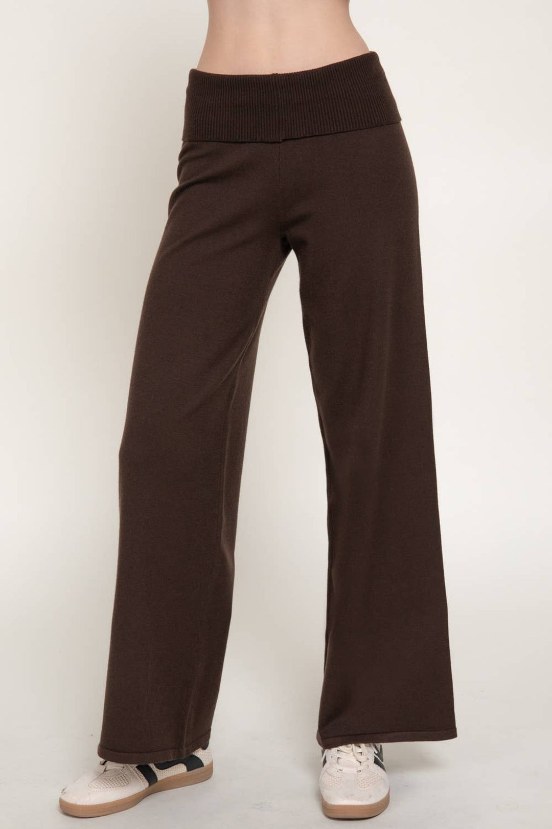 Side view of the brown fold over waist sweater pants showing the wide leg drape and sneakers
